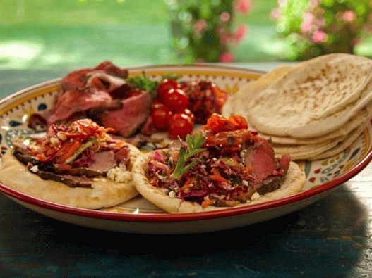 Foto de Pita cu miel în glazură de rodie cu mentă pe o scuipă, roșii la grătar și salată de varză grecească