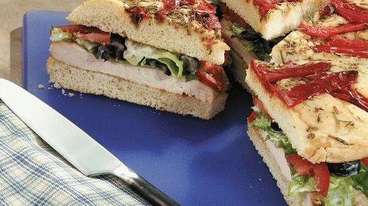 Fotografie a unui sandwich cu focilla tortilla cu pui murat și o răspândire de spanac și anghinare