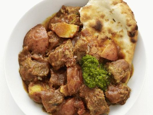 Foto cu carne de vită fiartă într-un aragaz lent, cu curry și cartofi